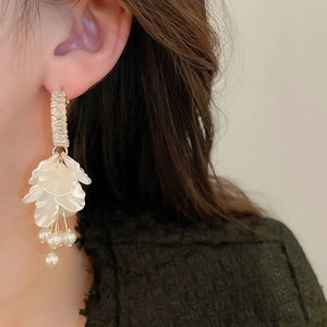Detail of floral drop earrings with sparkling cubic zirconia and elegant white pearls