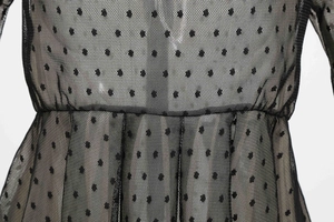 Detailed view of black polka dot mesh dress featuring pleated waist and mesh texture