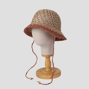Handwoven hollow straw sun hat with red-brown trim and tassel chin strap for summer travel