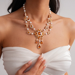 Detailed close-up of a vintage double-layer necklace with pearls and amber gemstones
