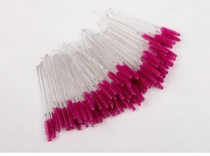 Flat lay of disposable rose red eyebrow brushes with sparkling silver glitter handles