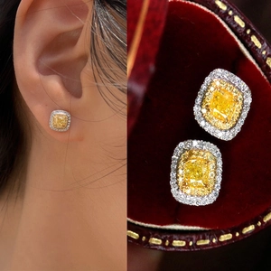 Detailed view of square yellow zircon stud earrings with halo setting on model and box