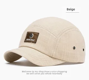 Close-up of beige plaid texture on five-panel cap with brown leather brand label
