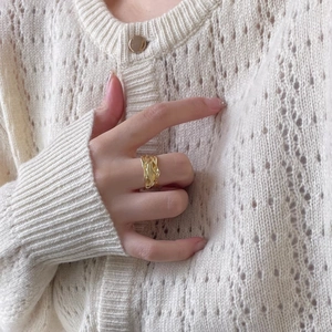 Close-up of golden irregular textured S925 sterling silver ring worn by a model