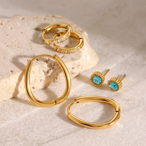 Close-up of 18k gold plated stainless steel earrings with zircon and sky blue gemstones