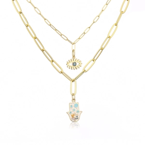 Close-up of 18K gold plated Hamsa hand and evil eye pendant with zircon details