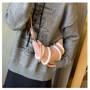 Rosa Wildleder-Crossbody-Tasche mit Lammfell-Besatz am Model im Detail gezeigt