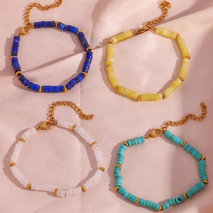 Detail of beaded bracelets with natural stones and gold lobster clasp on silk fabric