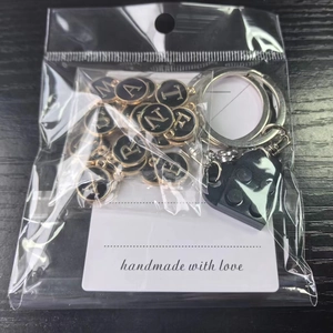 DIY alphabet heart block keychain set with gold letter charms on dark wood background