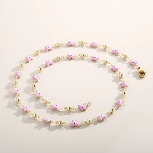 Detail of gold beaded necklace featuring pink enamel butterfly charms and lobster clasp