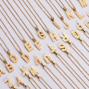 Macro view of 18K gold plated alphabet necklaces with unique stone texture detail