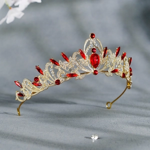 Détail d'une couronne baroque dorée aux motifs ajourés complexes et strass rouges brillants