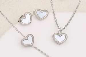 Detailed set of silver stainless steel shell heart necklace, bracelet, and earrings