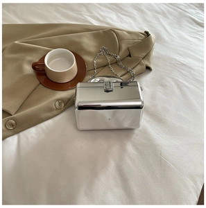 Detailed top view of a silver mirror acrylic box bag with metal chain and top handle
