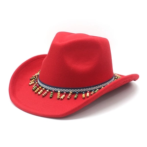 Detail of red felt cowboy hat featuring ethnic woven band and colorful wooden bead tassels