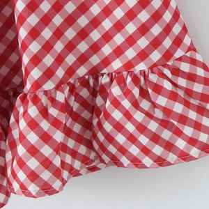 Gros plan sur le tissu à carreaux vichy rouge et blanc avec détails de volants