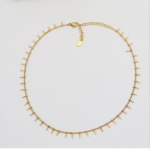 Dettaglio di collana placcata oro 18K con ciondoli rettangolari e punzonatura K18