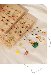 Détail de colliers en titane doré avec pierres naturelles colorées sur velours