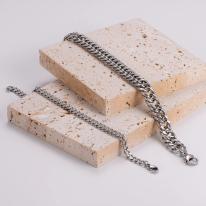 Silver stainless steel curb link bracelets in two widths on stone display