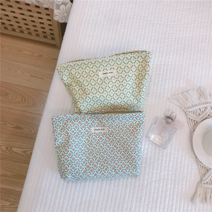Detailed top view of two floral cotton makeup bags with simple wish labels and zippers