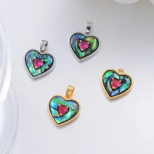 Detail of 18K gold and silver heart pendants with abalone shell and red zircon inlay