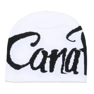 Detailed close-up of white knitted beanie featuring black cursive letter jacquard patterns