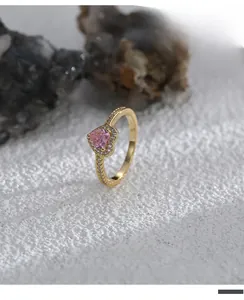 Detailed view of heart-shaped pink zircon ring with gold plating and pavé diamond setting