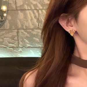 Exquisite 14k gold plated maple leaf stud earrings with sparkling zircon on model's ear