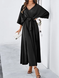 Detail view of black V-neck maxi dress with batwing sleeves and side slits at the waist