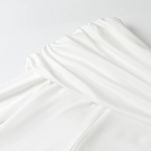 Close-up of elegant pleated white satin fabric texture on a formal long dress shoulder