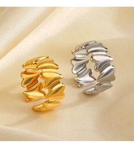 Close-up of gold and silver heart-shaped adjustable rings on soft beige silk background