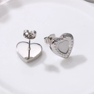 Detail of silver heart stud earrings with beaded edges and polished stainless steel finish