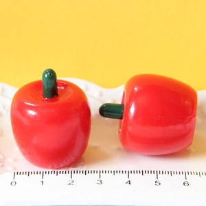 Realistic red apple resin charms for DIY crafts and ornaments on white background
