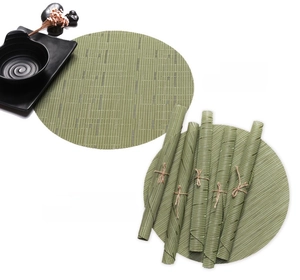 Detail of round grass green woven placemats showing bamboo texture and rolled storage
