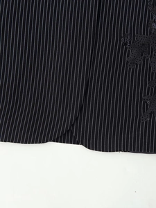Détail de l'ourlet du blazer à rayures avec sequins noirs et couture raffinée