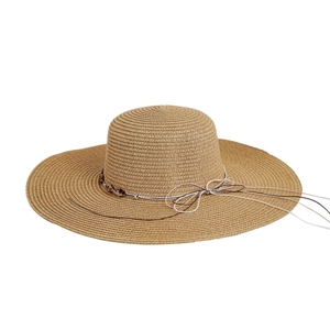 Detail of khaki straw sun hat featuring a decorative string bow and dark brown beads