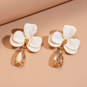Vue macro détaillée de boucles d'oreilles à fleurs avec pétales blancs et cristaux