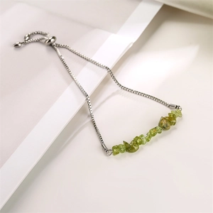 Detailed shot of an adjustable silver box chain bracelet with light green gemstone beads