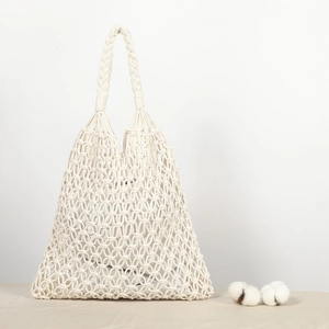 Detail shot of ivory woven cotton rope mesh bag featuring a rural pastoral style handle