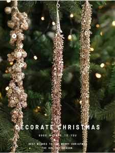 Detail of glittery gold and pink sequined Christmas tree ornaments with bead tassels