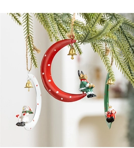 Detailed view of festive resin figurines on iron moon hangers with small bells and ropes