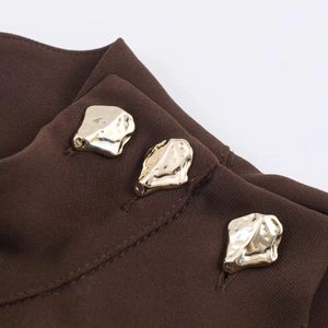 Detail of artistic gold lava-style buttons on dark coffee twill knit dress with belt