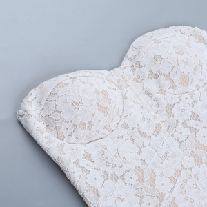 Close-up detail of white lace corset top showing intricate embroidery and padded bust cups