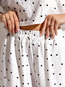 Détail de l'ensemble blanc deux pièces avec broderie ajourée et motif cœurs noirs