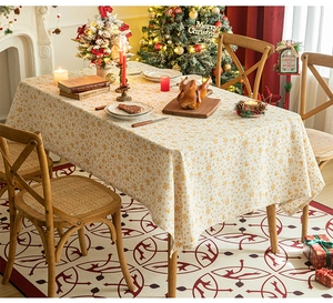 Close-up of beige Christmas tablecloth with golden snowflake patterns and festive decor