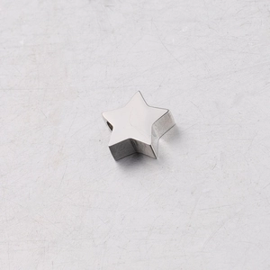 Macro shot of mirror-polished silver stainless steel star pendant bead with smooth surface