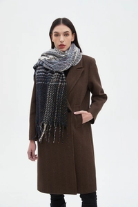 Close-up of multi-color plaid scarf with fringes styled on a brown herringbone coat