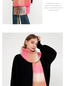 Detailed close-up of soft pink and beige plaid scarf with decorative long tassels