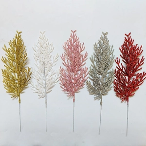 Detail of five glitter pine branches in gold silver red pink and white on white backdrop