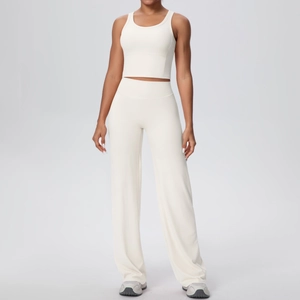 Dettaglio set yoga bianco con canotta corta e pantaloni larghi a vita alta su modella